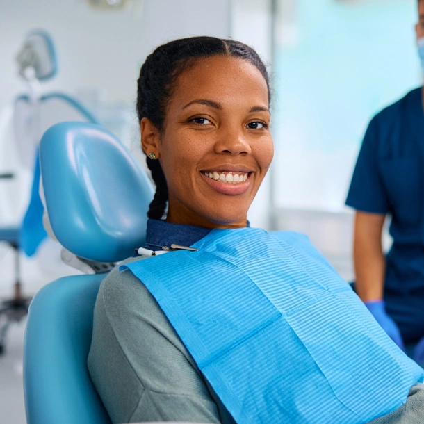 Smiling woman in dental chair at St. Helena Dental Studio wearing blue bib.